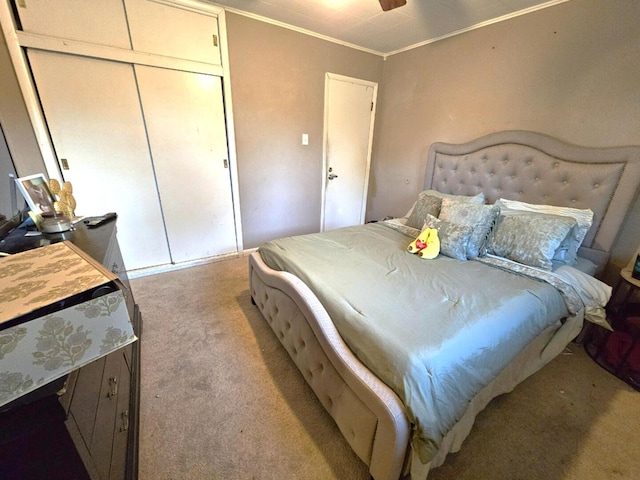 bedroom with ornamental molding, a closet, and light colored carpet