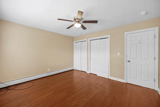 405 E 109th St Unit 203, Chicago, IL 60628 - unfurnished bedroom featuring two closets, wood finished floors, a baseboard heating unit, and a ceiling fan