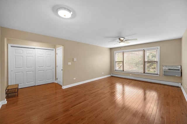 405 E 109th St Unit 203, Chicago, IL 60628 - unfurnished living room with a baseboard heating unit, a wall mounted AC, a ceiling fan, and wood finished floors