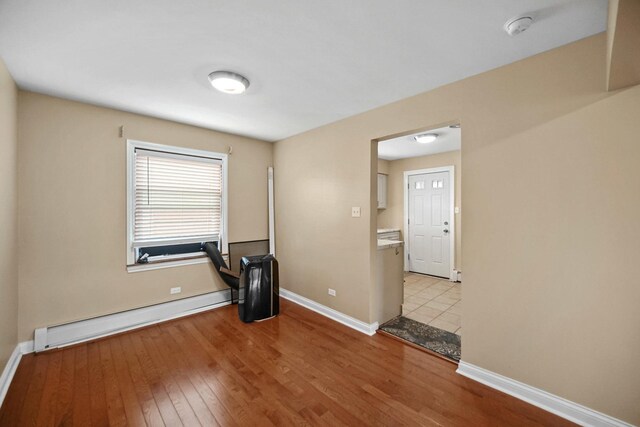 405 E 109th St Unit 203, Chicago, IL 60628 - spare room featuring a baseboard radiator, a smoke detector, and light wood-type flooring