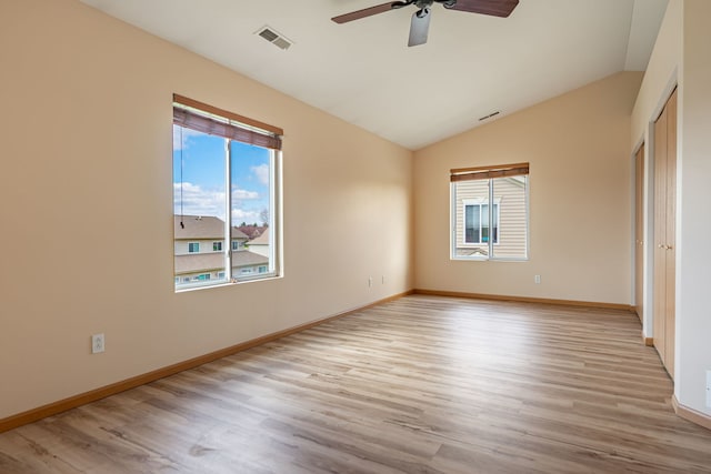7480 Thomas Dr Unit 7480, Loves Park, IL 61111 - unfurnished bedroom featuring lofted ceiling, multiple windows, wood finished floors, and visible vents