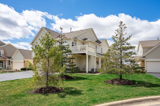 7480 Thomas Dr Unit 7480, Loves Park, IL 61111 - view of front of property with a front lawn, a garage, concrete driveway, and a balcony