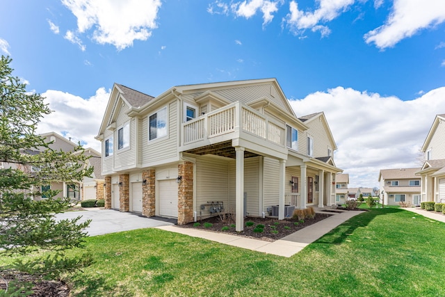 7480 Thomas Dr Unit 7480, Loves Park, IL 61111 - view of side of home with a balcony, aphalt driveway, stone siding, an attached garage, and a lawn