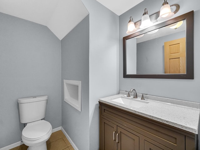 bathroom featuring vanity, toilet, tile patterned floors, baseboards, and lofted ceiling
