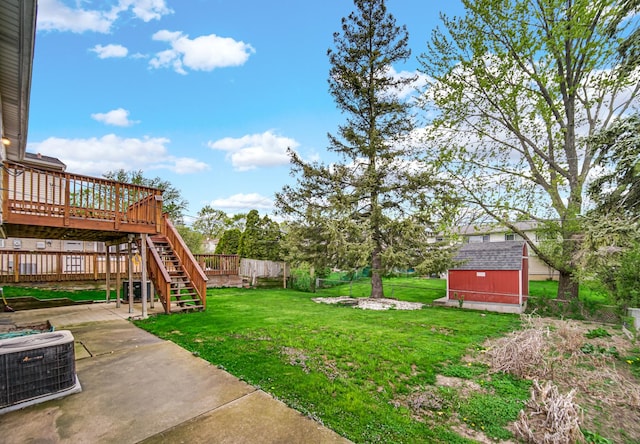 view of yard with an outdoor structure, a storage shed, a deck, central air condition unit, and a patio