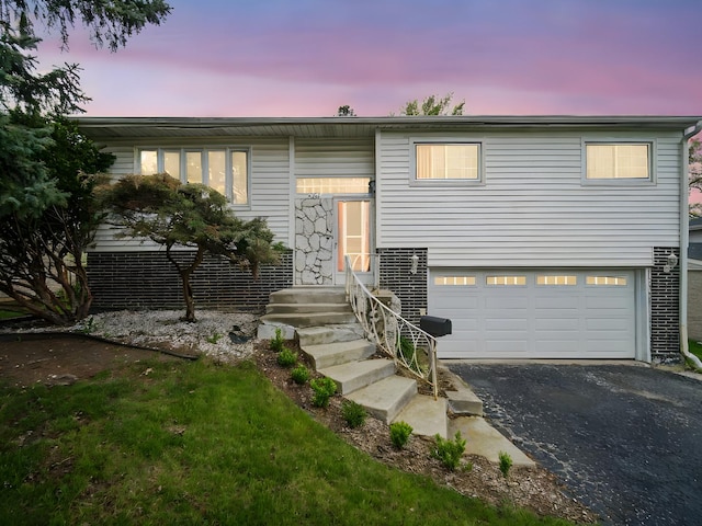 bi-level home with aphalt driveway and a garage