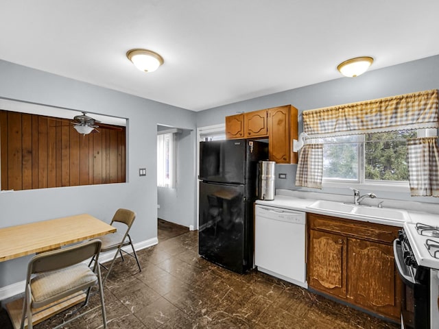 kitchen featuring gas range, dishwasher, a sink, light countertops, and freestanding refrigerator