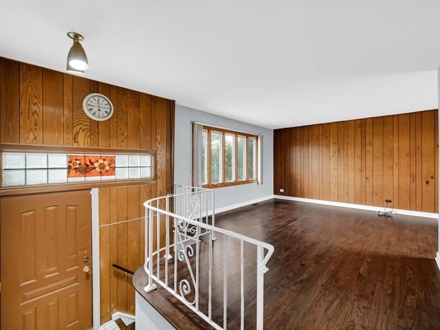 entryway with baseboards, wood finished floors, and wooden walls