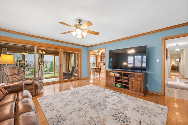living room featuring baseboards, ceiling fan, crown molding, and light wood-style flooring