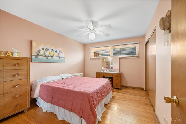 bedroom featuring ceiling fan, light wood-type flooring, baseboards, and a closet