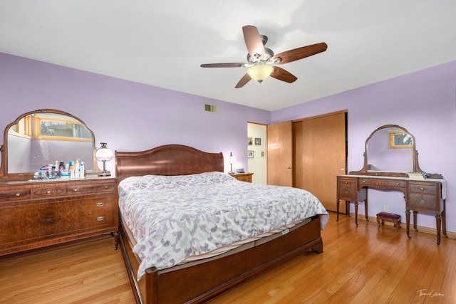 bedroom featuring ceiling fan, visible vents, light wood-type flooring, and a closet