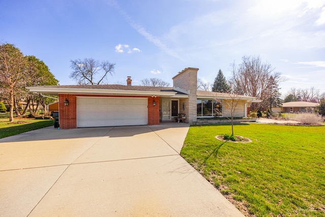 view of front facade with a front yard, a chimney, driveway, brick siding, and an attached garage