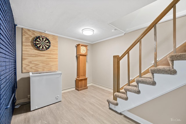 interior space with stairs, refrigerator, ornamental molding, and wood finished floors