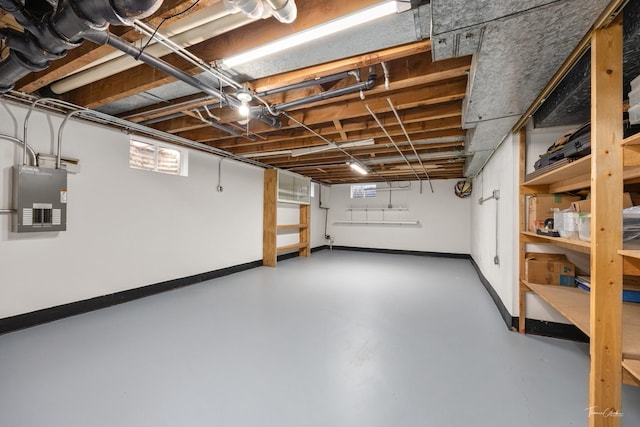 basement featuring electric panel and baseboards