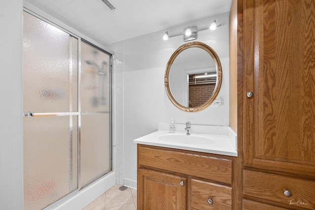 full bath with tile patterned floors, vanity, a shower stall, and visible vents
