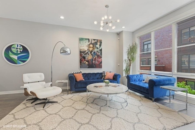 living area with baseboards, recessed lighting, wood finished floors, and an inviting chandelier