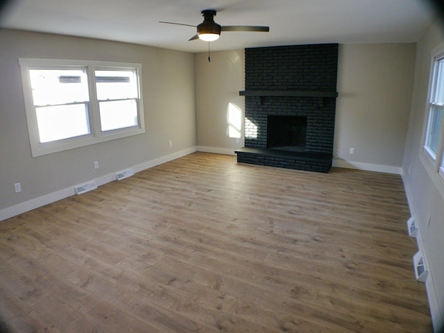 unfurnished living room with visible vents, ceiling fan, and a wealth of natural light