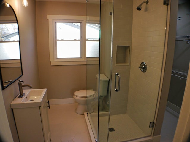 bathroom featuring toilet, a healthy amount of sunlight, and a shower stall