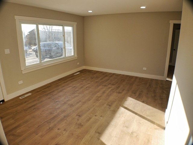 unfurnished room with recessed lighting, visible vents, wood finished floors, and baseboards