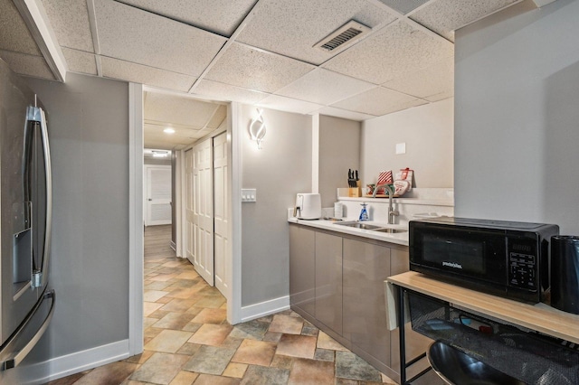 11702 Center Dr, Lemont, IL 60439 - bar with a sink, stone finish floor, visible vents, baseboards, and black microwave