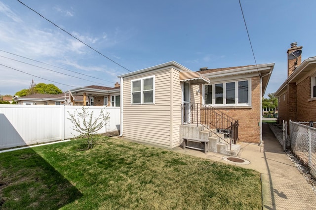 7313 W Howard Ave, Chicago, IL 60631 - back of house with a lawn, brick siding, and a fenced backyard