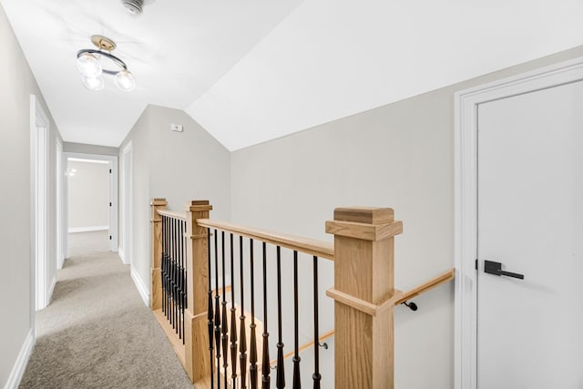 hallway featuring baseboards, an upstairs landing, and carpet floors