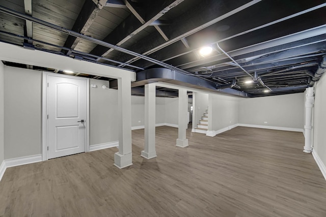 finished basement with wood finished floors, stairs, and baseboards