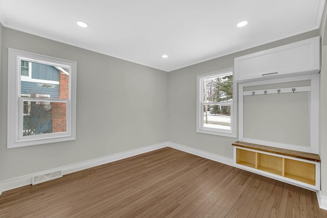 unfurnished living room with recessed lighting, light wood-type flooring, baseboards, visible vents, and crown molding