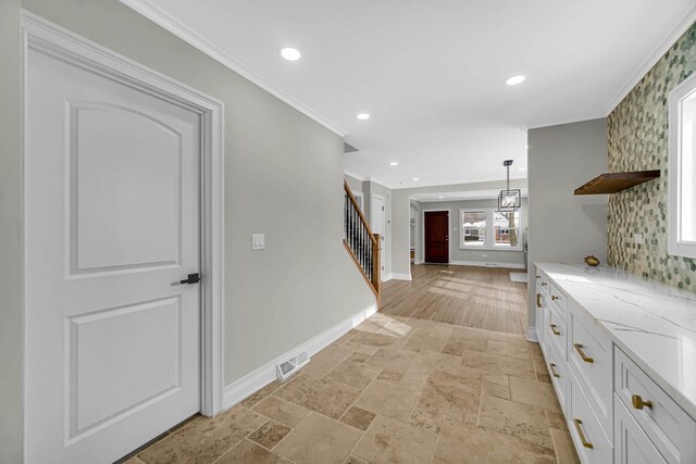 hall featuring recessed lighting, stairway, stone tile flooring, crown molding, and baseboards