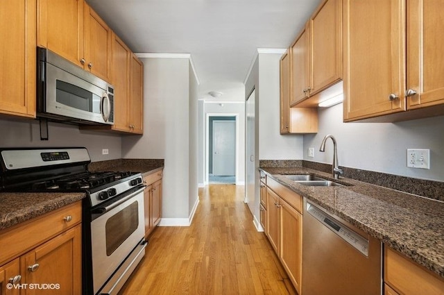 201 N Westshore Dr Unit 1207, Chicago, IL 60601 - kitchen featuring appliances with stainless steel finishes, a sink, light wood-style flooring, and dark stone countertops