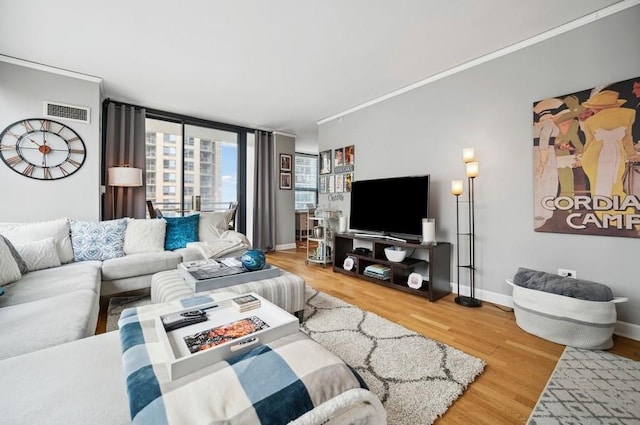living area with baseboards, wood finished floors, and visible vents