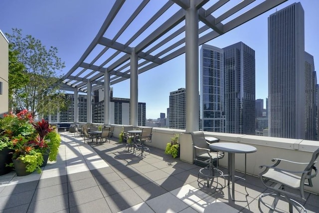 view of patio with outdoor dining area, a city view, and a pergola
