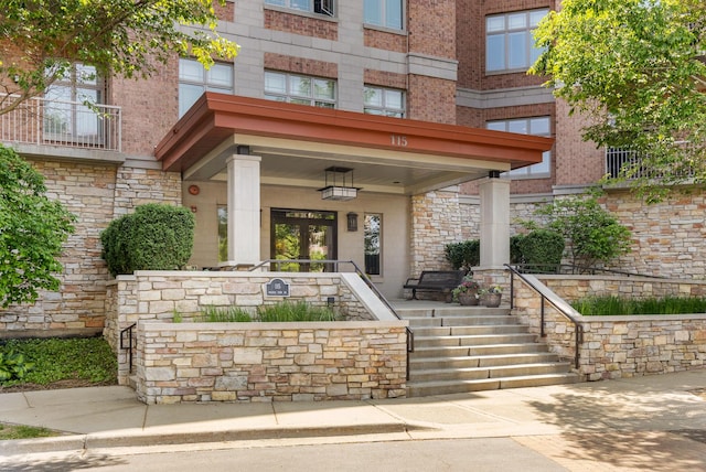 doorway to property featuring brick siding and a porch