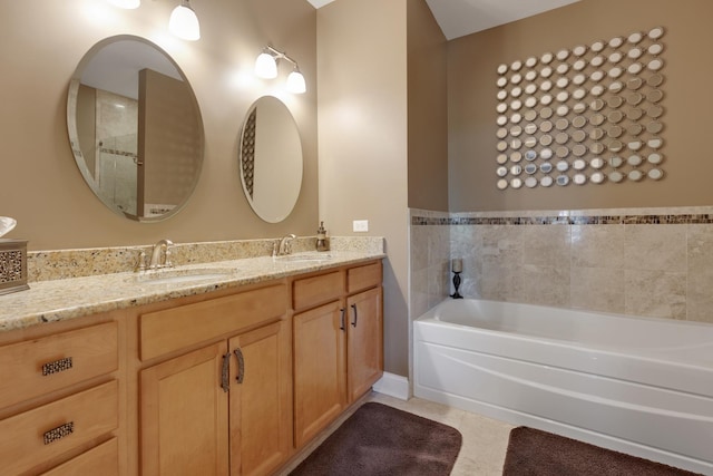 bathroom featuring tile patterned floors, double vanity, a bath, and a sink