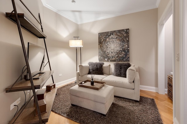living room featuring baseboards, ornamental molding, and wood finished floors