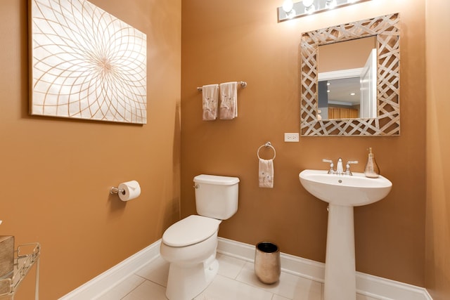 bathroom with toilet, tile patterned flooring, and baseboards