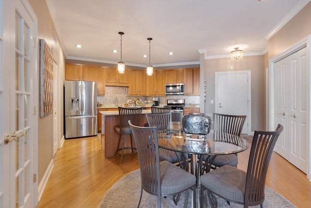 dining space with ornamental molding, recessed lighting, baseboards, and light wood-type flooring