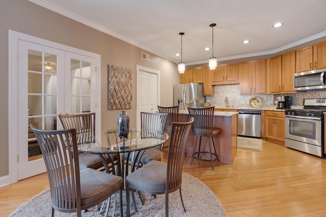 dining area with ornamental molding, light wood finished floors, recessed lighting, and visible vents