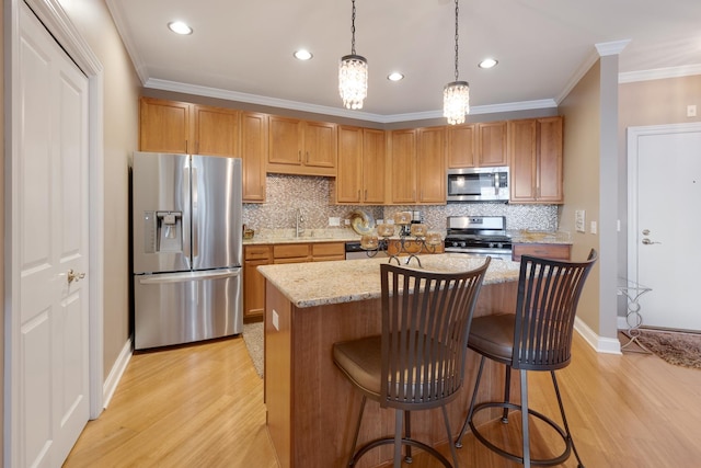 kitchen featuring crown molding, appliances with stainless steel finishes, light wood-style flooring, and decorative backsplash