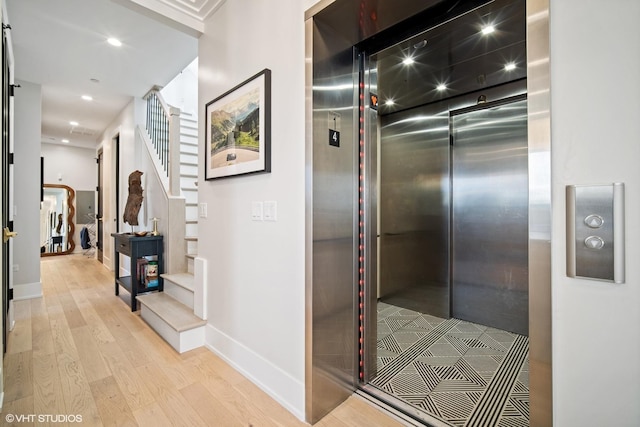 hall with recessed lighting, stairway, elevator, baseboards, and wood finished floors
