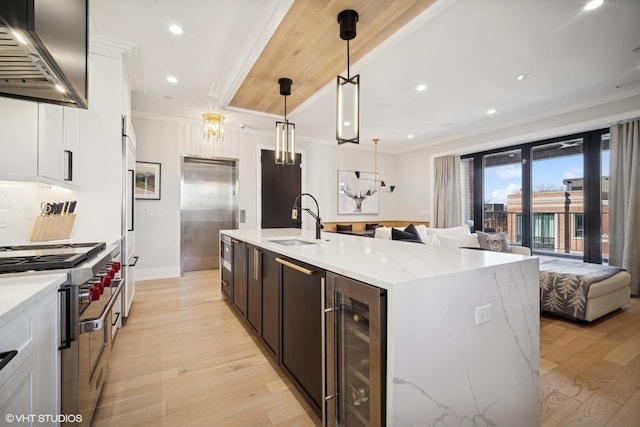kitchen featuring beverage cooler, open floor plan, high quality appliances, and range hood