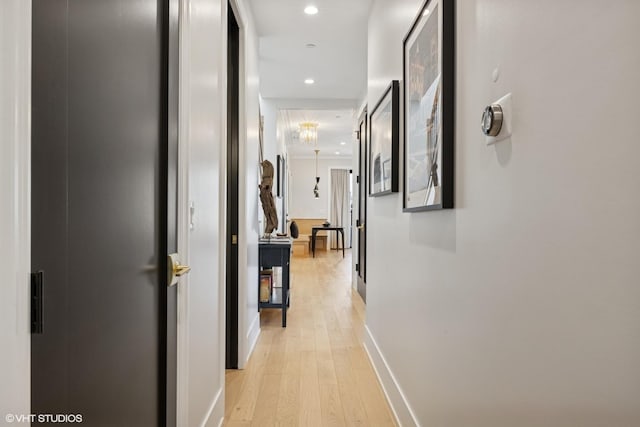 hallway with light wood-type flooring, recessed lighting, and baseboards