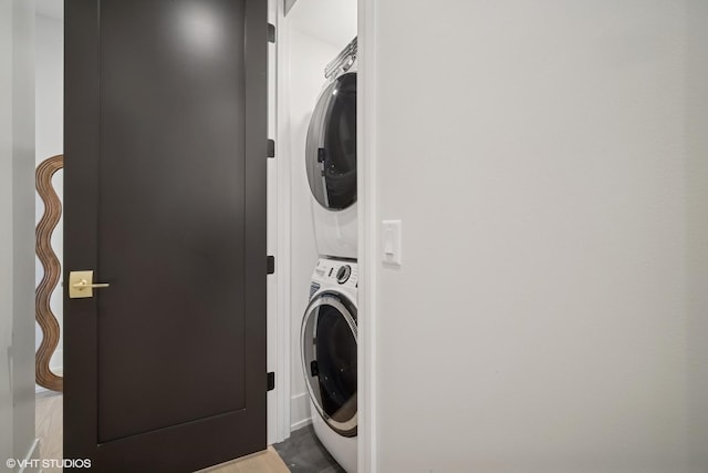 washroom with stacked washer / drying machine and laundry area
