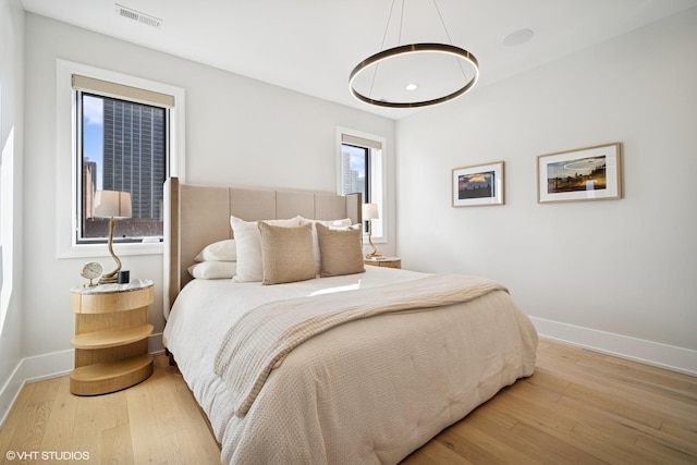 bedroom featuring baseboards, visible vents, and wood-type flooring