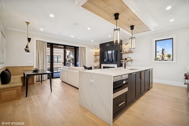 kitchen featuring a wealth of natural light, light wood finished floors, and a sink