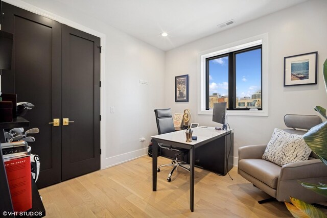 office area with light wood-type flooring, recessed lighting, visible vents, and baseboards