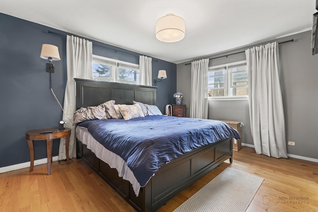 bedroom with baseboards and light wood finished floors