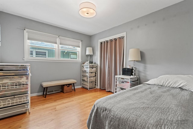 bedroom featuring light wood finished floors and baseboards