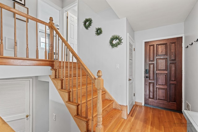 entryway featuring wood finished floors, stairway, and baseboards