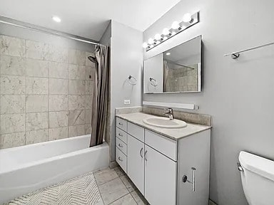 bathroom with vanity, toilet, tile patterned flooring, and shower / bath combo